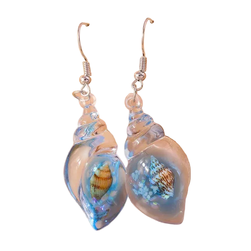 Shell-shaped earrings with sea-themed design on a beige background