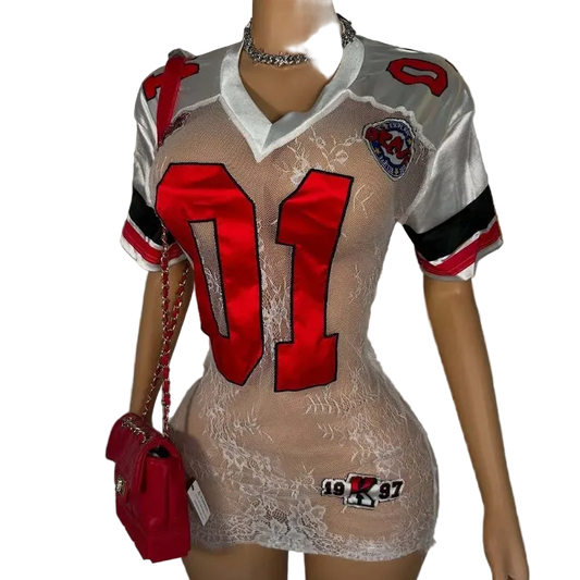 Mannequin wearing a sheer dress with red numbers and a red purse, against a plain background.
