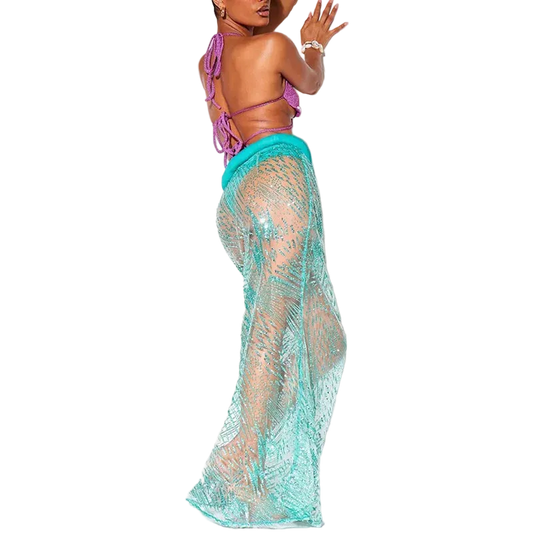 Woman wearing a purple bikini top and teal lace cover-up on a white background