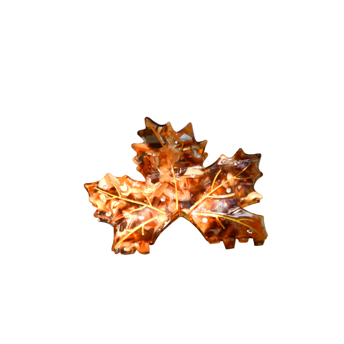 A decorative glass leaf sculpture made from an orange-brown oak leaf, mounted on a tree branch outdoors with a blurred natural background.