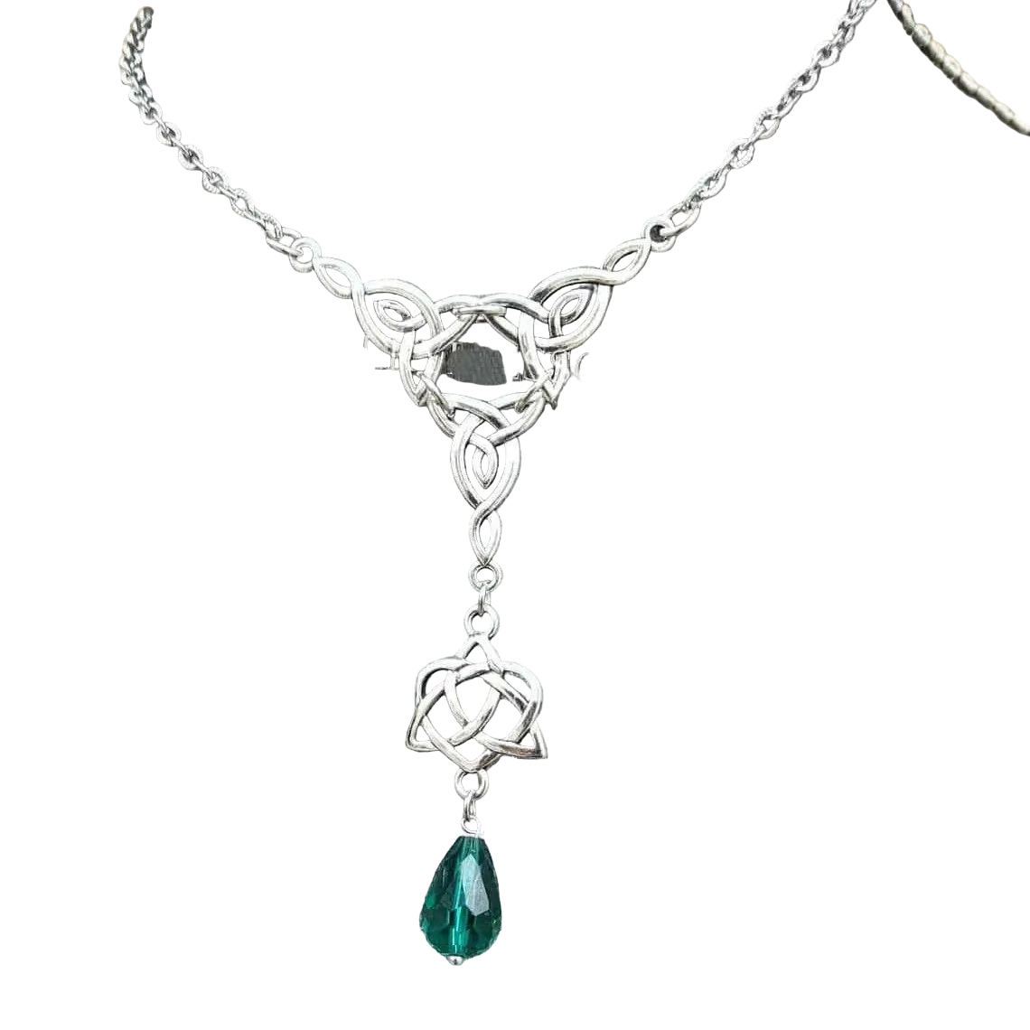 A silver-toned Celtic knot lariat necklace with a teardrop-shaped green gemstone pendant, displayed on a gray fabric jewelry bust.