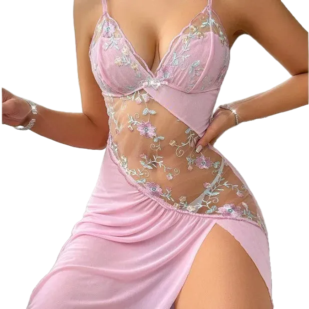 A woman wearing a light pink lingerie chemise with floral embroidered lace panels and sheer mesh details, shown against a plain white background.
