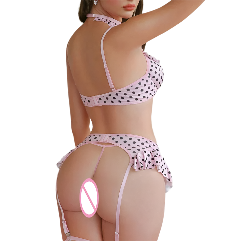 Person wearing a polka dot lingerie set in a bedroom setting with pink decor.