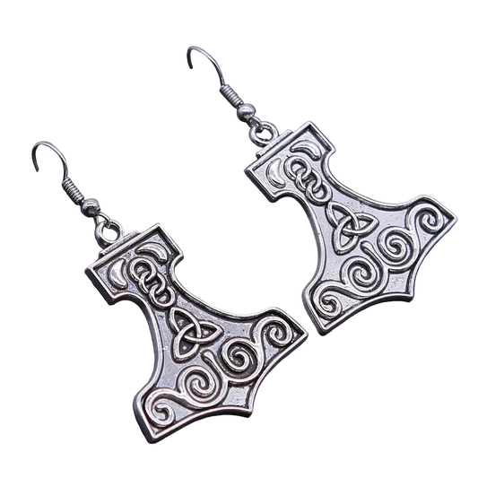A pair of silver-toned drop earrings shaped like Mjolnir, featuring Celtic knotwork details, displayed on a dark textured surface.