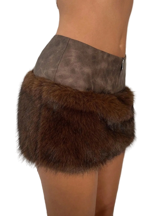 A close-up side view of a model wearing a brown faux fur wrap skirt with a taupe faux leather waistband.