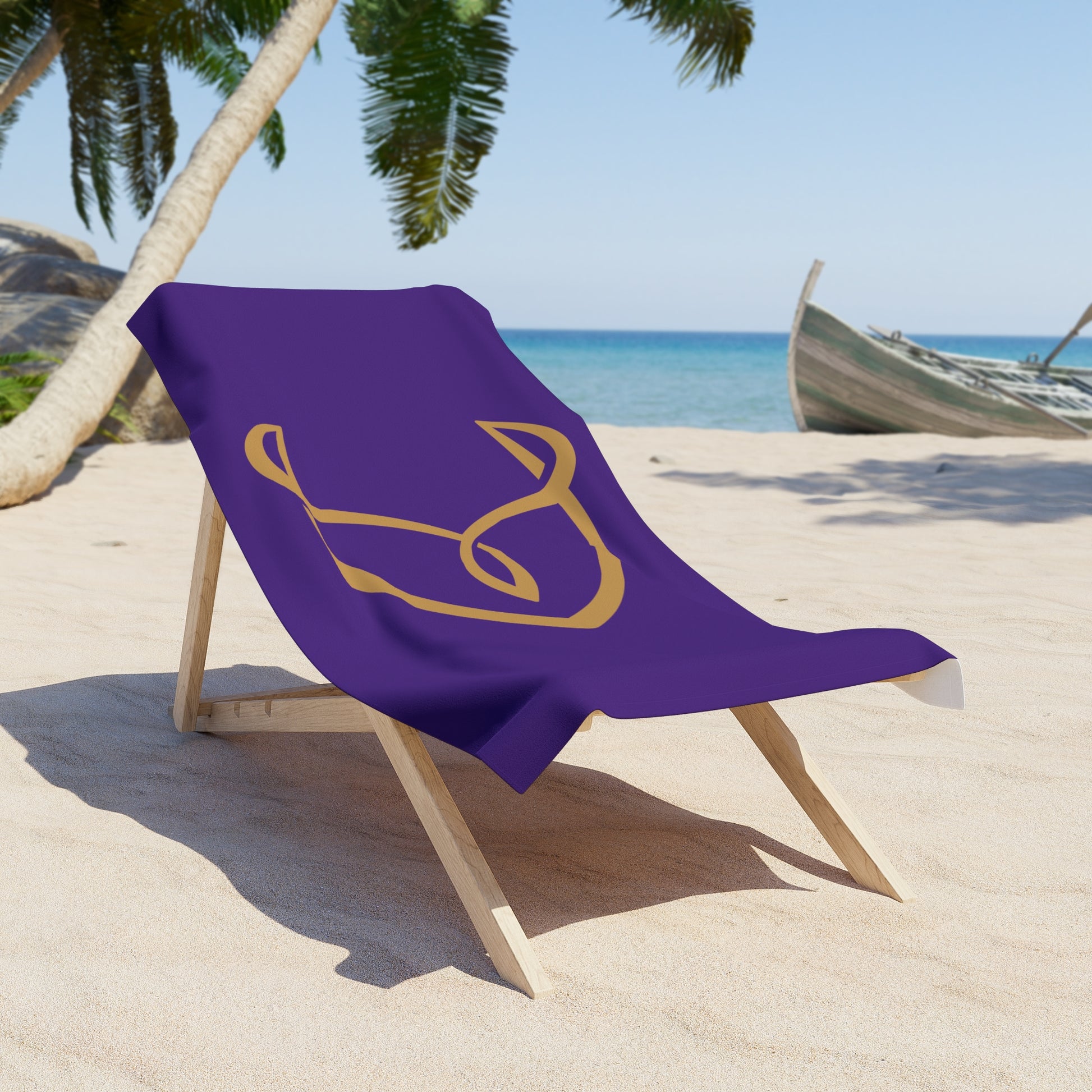 Purple towel with a gold Desire 
symbol draped over a beach chair on a sandy beach with palm trees and ocean in the background.