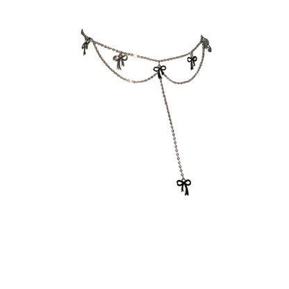 A close-up of a model's neck and upper chest wearing a delicate silver-toned double-layered choker necklace with small bow charms and a long dangle chain ending in a bow.