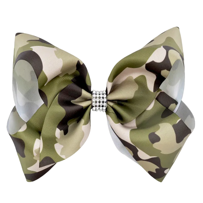 A large bow tie with an olive green, beige, and black camouflage pattern, featuring a small rhinestone-embellished center band, shown on a plain white background.