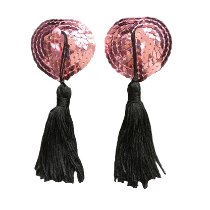 Pair of pink sequin heart-shaped earrings with black tassels on a gray background