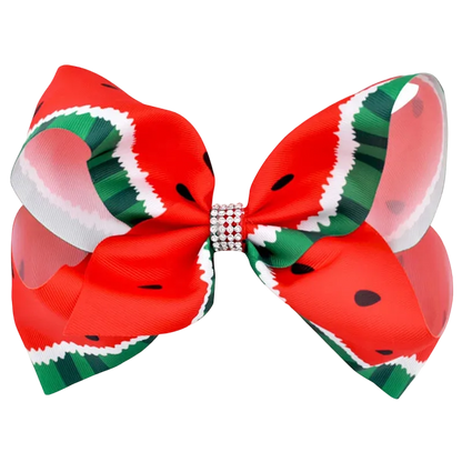 A large hair bow featuring a watermelon print with red, green, white, and black patterns, secured in the center with a rhinestone-embellished band, shown on a plain white background.