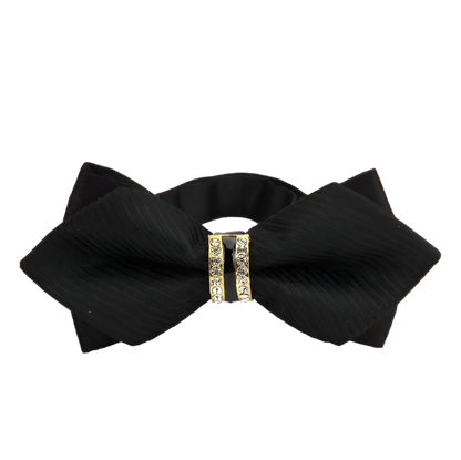 Black bow hair accessory with gold embellishments on a white background