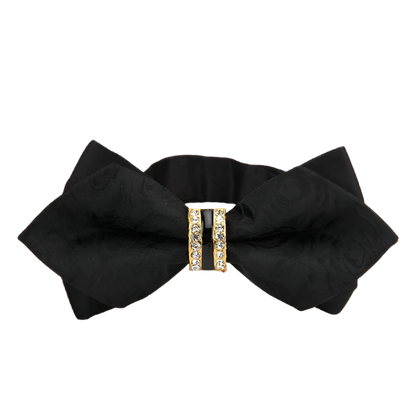 Black bow hair clip with a gold buckle on a white background