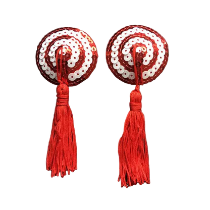 Pair of red and white sequin earrings with tassels on a dark background