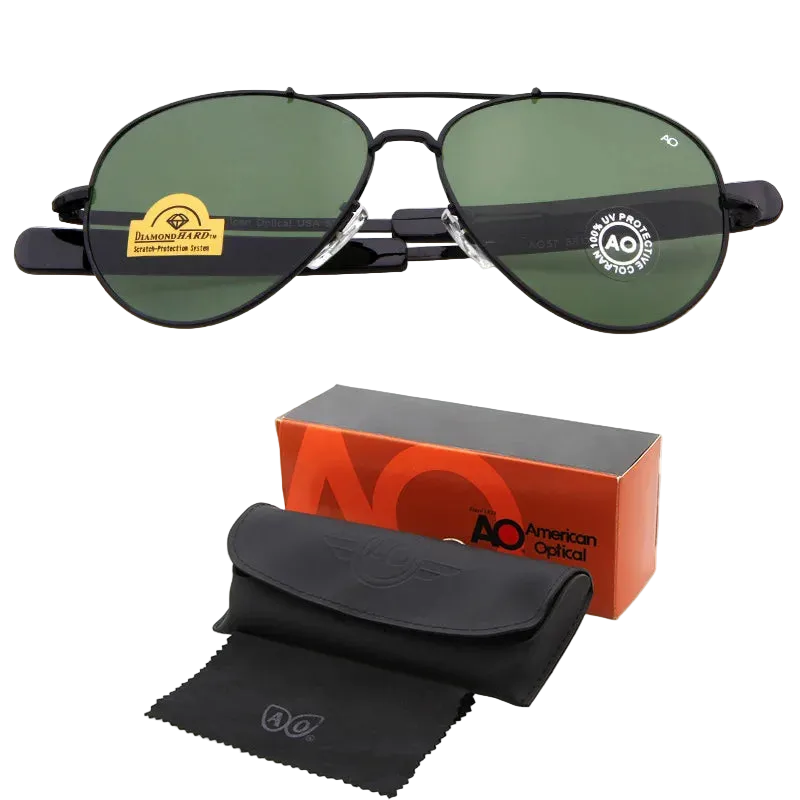 A pair of aviator-style sunglasses with dark green lenses and black frames, shown above their packaging accessories including an orange and black AO box, a black case, and a black microfiber cloth. The text 'C3+ BOX' is visible in the bottom right corner.