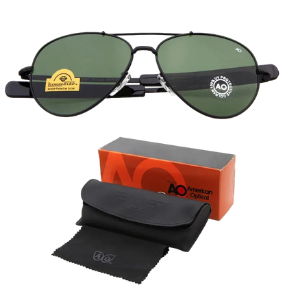 A pair of aviator-style sunglasses with dark green lenses and black frames, shown above their packaging accessories including an orange and black AO box, a black case, and a black microfiber cloth. The text 'C3+ BOX' is visible in the bottom right corner.
