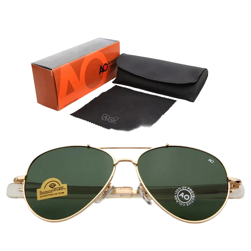 Gold aviator sunglasses with dark green lenses, shown with an orange and gray AO Cutie box, a black case, and a black microfiber cloth on a white background.