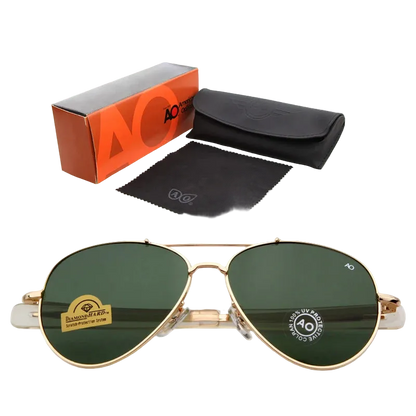 Gold aviator sunglasses with dark green lenses, shown with an orange and gray AO Cutie box, a black case, and a black microfiber cloth on a white background.