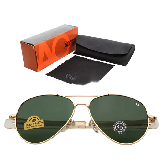 Gold aviator sunglasses with dark green lenses, shown with an orange and gray AO Cutie box, a black case, and a black microfiber cloth on a white background.