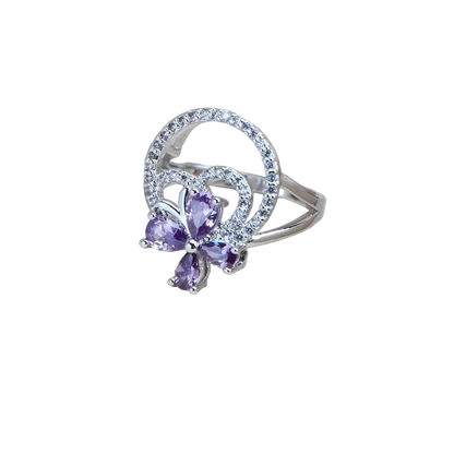 Silver ring with purple gemstones on a light background
