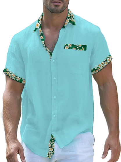 Man wearing a light blue shirt with floral patterns in an outdoor setting