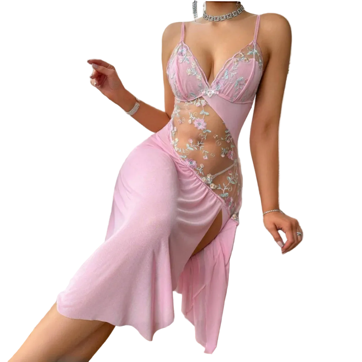 A woman models a light pink satin slip dress with floral embroidery and sheer mesh panels, sitting on a white textured armchair in a bright room.