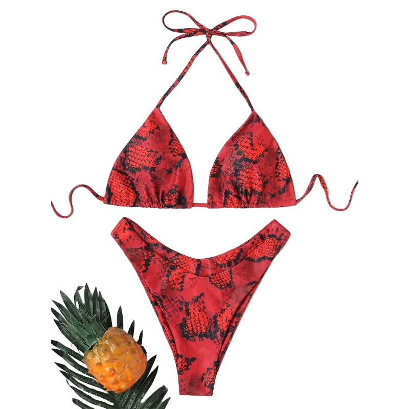 Red snake print bikini set with a straw hat and pineapple on a white background