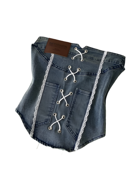 Denim pet corset with lace details on a white surface