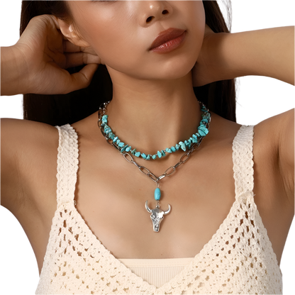 Woman wearing a turquoise necklace with a bull head pendant against a neutral background