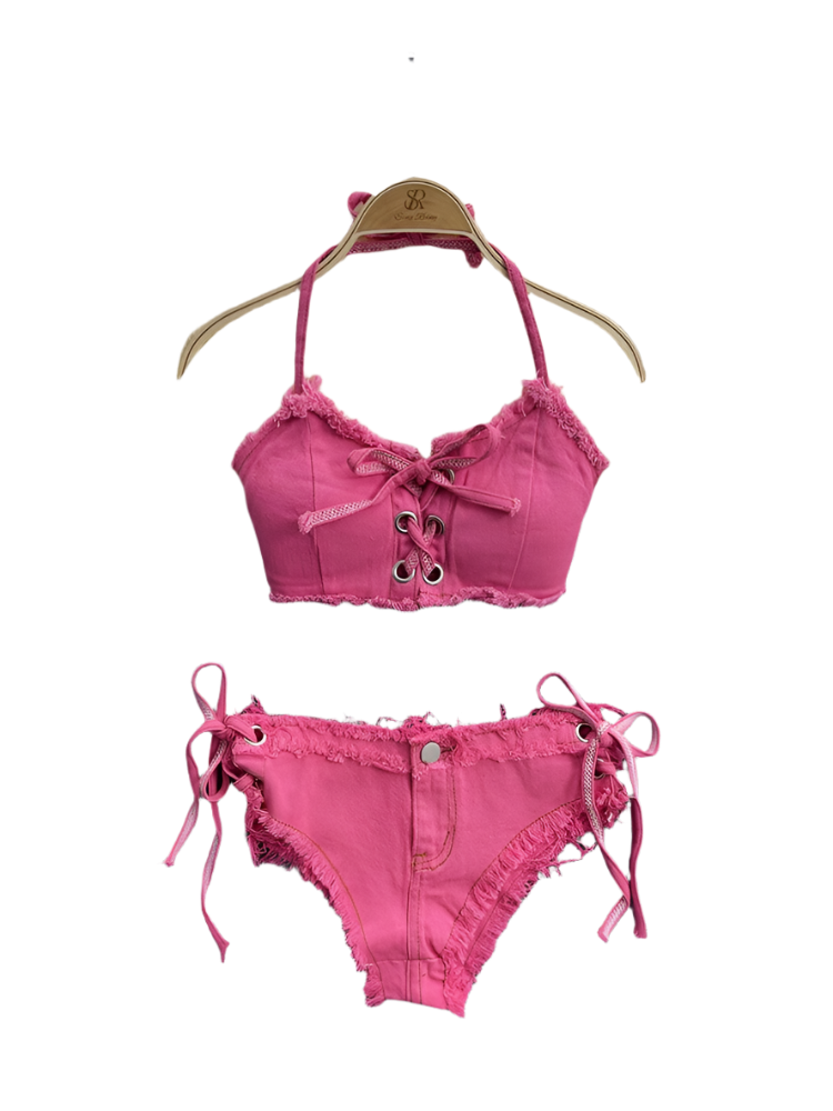 Pink bikini set with lace details on a hanger against a fluffy white surface.