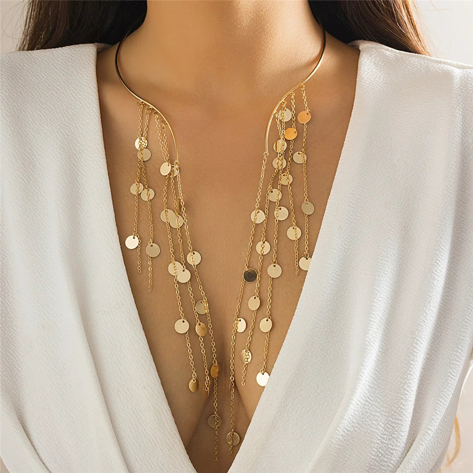 Gold layered necklace worn by a model in a white outfit