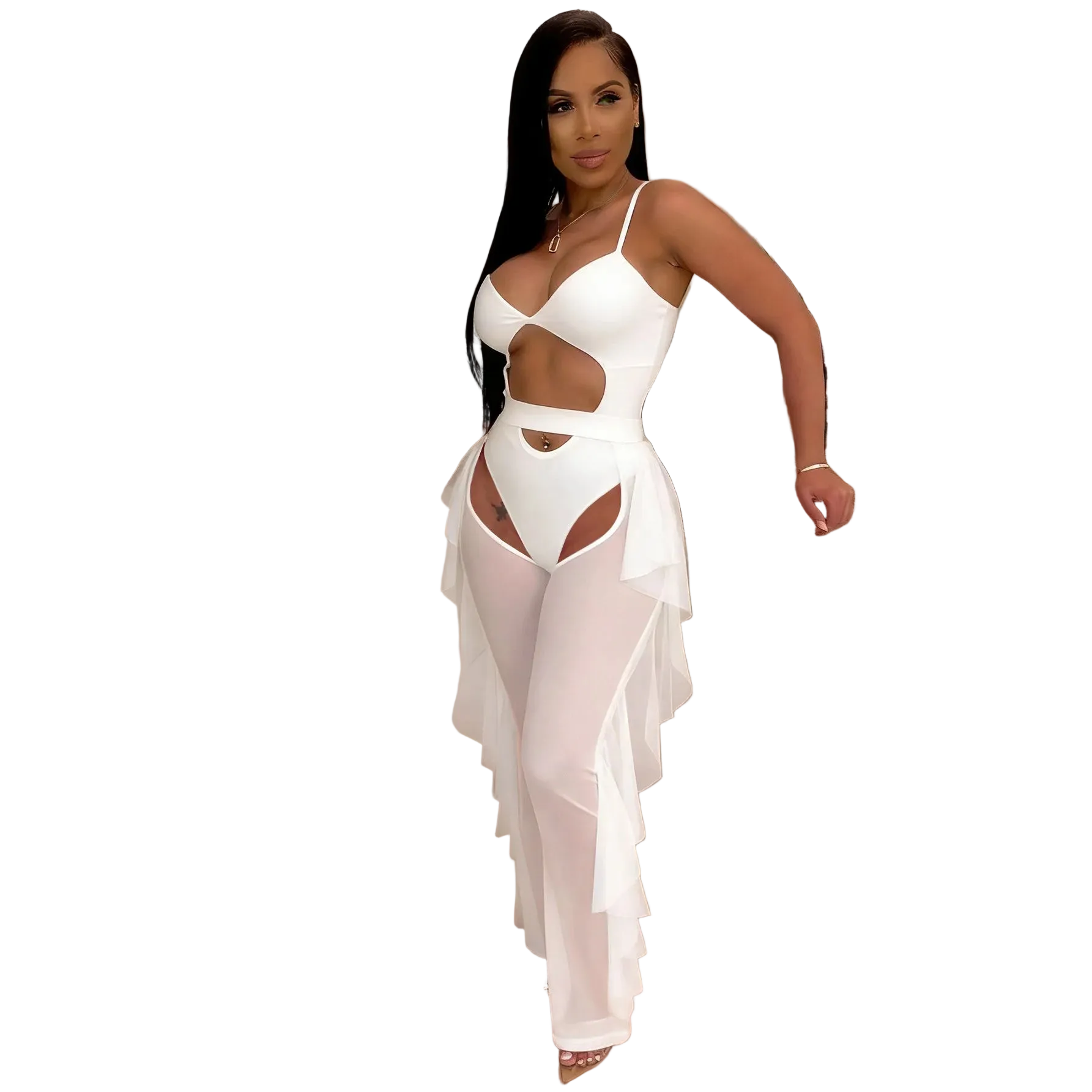 A woman modeling a white one-piece cutout dress with sheer ruffled overlay pants, standing in an indoor setting with a shelf and plants in the background.