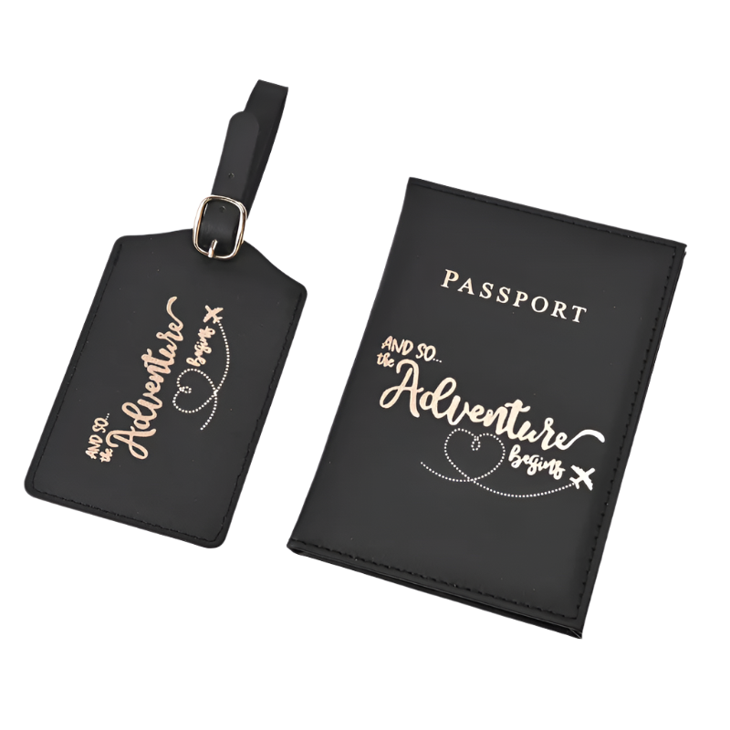 A passport holder and luggage tag set with the phrase "And so the adventure begins" in elegant script. The design is sleek and stylish, perfect for travel.