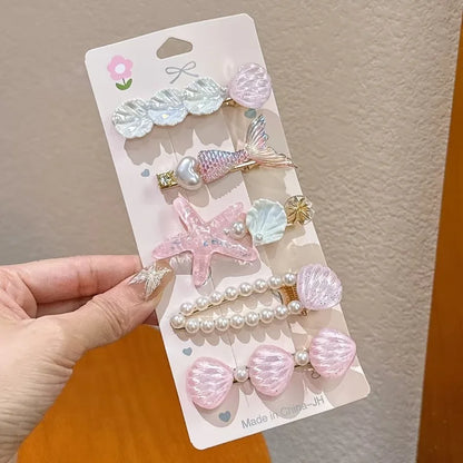 Set of decorative hair clips on a packaging card held by a hand.