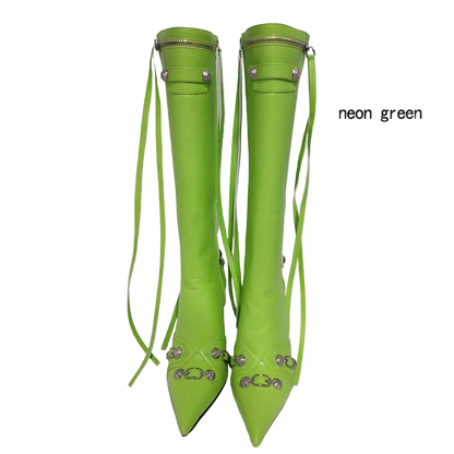 Neon green knee-high boots with decorative straps on a white background