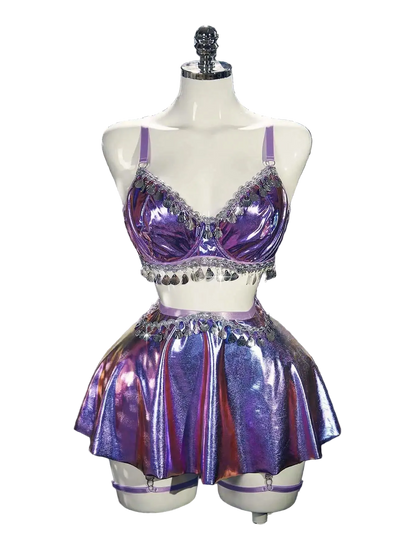 Purple sequin two-piece outfit on a mannequin against a silver tinsel background.