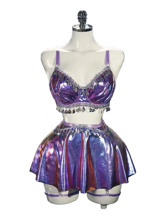 Purple sequin two-piece outfit on a mannequin against a silver tinsel background.