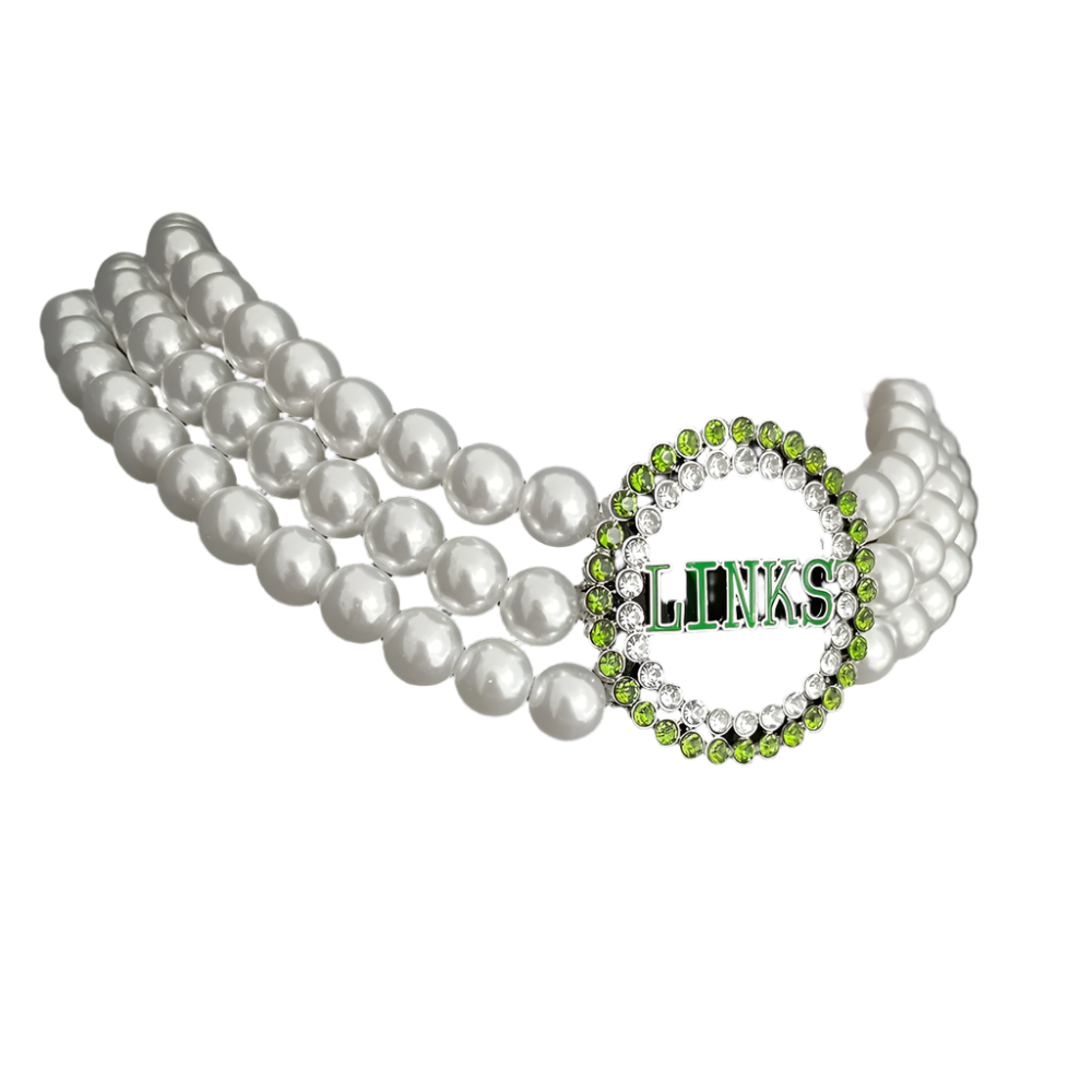 Pearl necklace and green and silver 'LINKS' bracelet on a black stand