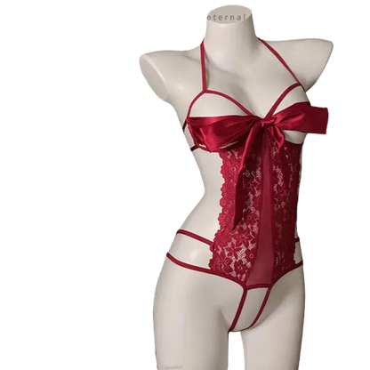 Red lace and satin lingerie set displayed on a white female mannequin against a black backdrop. The set includes a sheer lace corset-style top with a large satin bow at the bust, matching red strappy harness details, and coordinating panty bottoms.