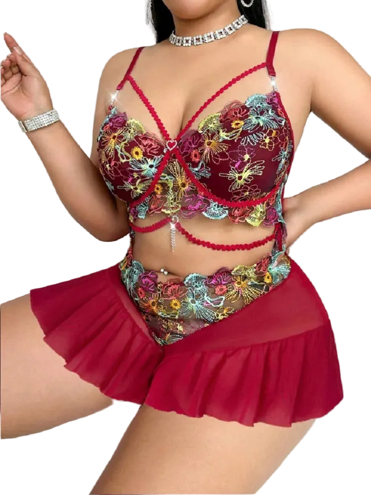Woman wearing a colorful embroidered lingerie set with red accents on a white background