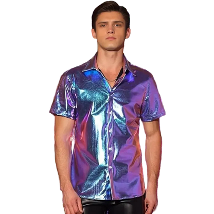 A man wearing a short-sleeve iridescent button-up shirt with a metallic purple, blue, and pink sheen, standing in front of a shiny tinsel curtain backdrop.