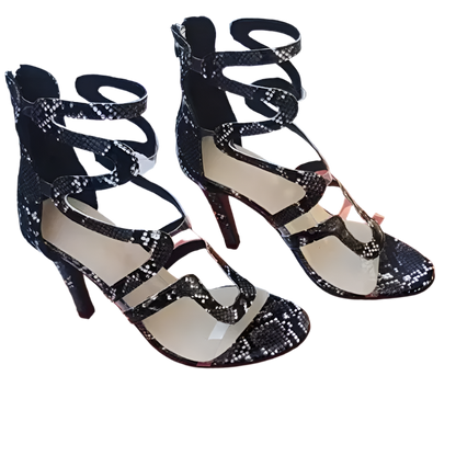 Black strappy high-heeled shoes on an orange 'fashion & shoes' box.