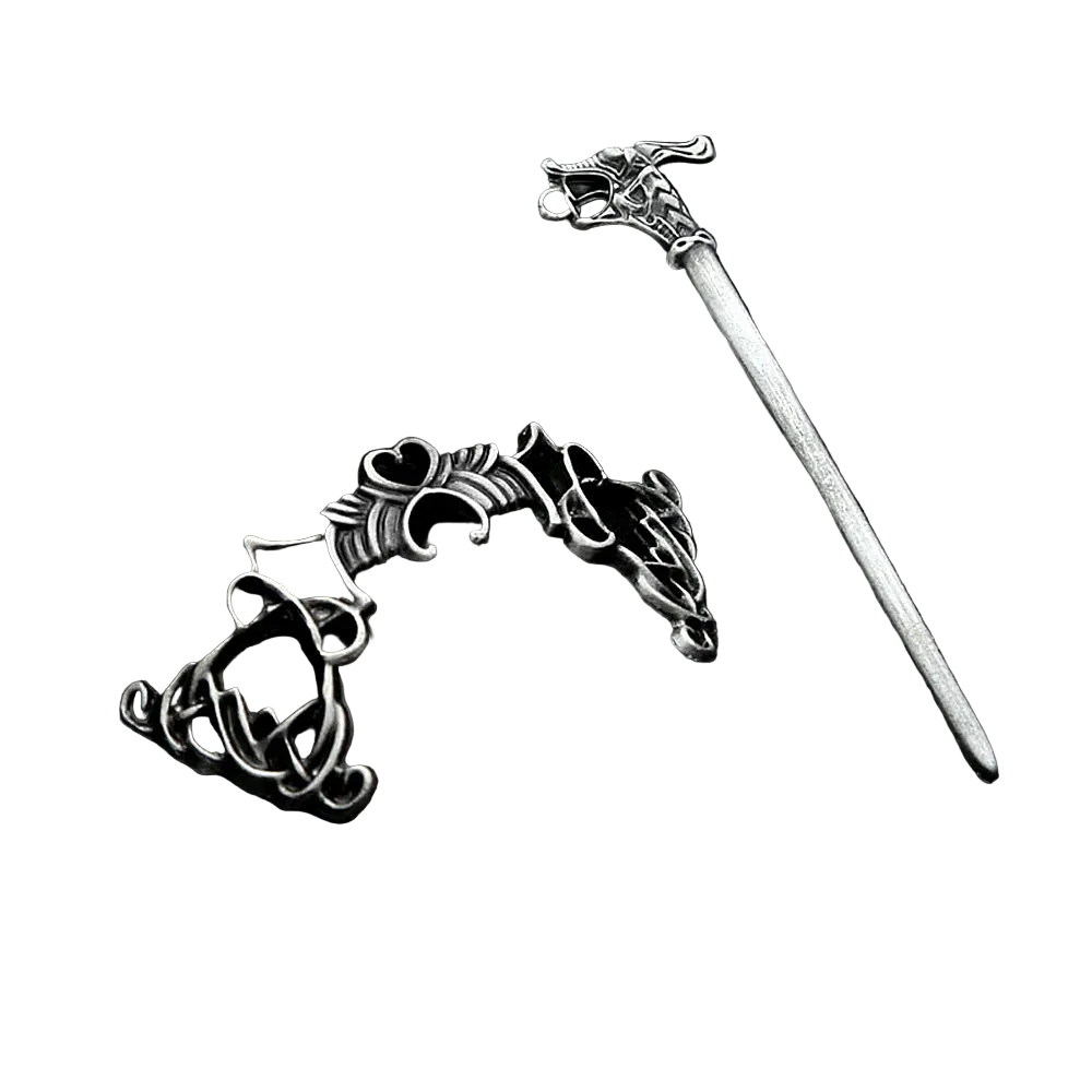 Silver hairpin with intricate design on a black textured surface