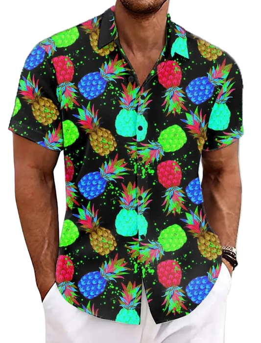 Man wearing a colorful pineapple pattern shirt on a beach.