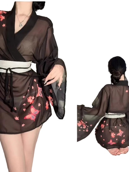 Person wearing a black kimono-style outfit with floral patterns, standing in a neutral setting.