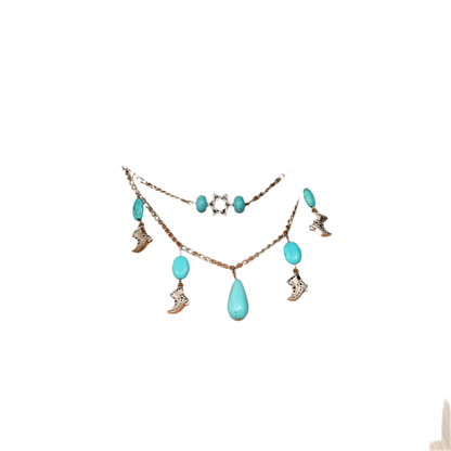 Necklace with turquoise stones and charms on a person wearing a white top