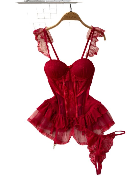 Red lace lingerie set on a hanger with flowers and a rug in the background
