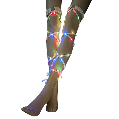 Legs wearing LED light-up leg straps on a black background