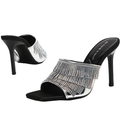 A pair of black and silver high-heeled mule sandals with a fringe of sparkling rhinestones across the open toe, shown on a clean white background.