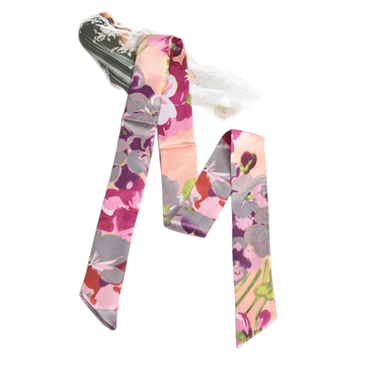 Floral patterned hair ties on a white surface with a magazine in the background