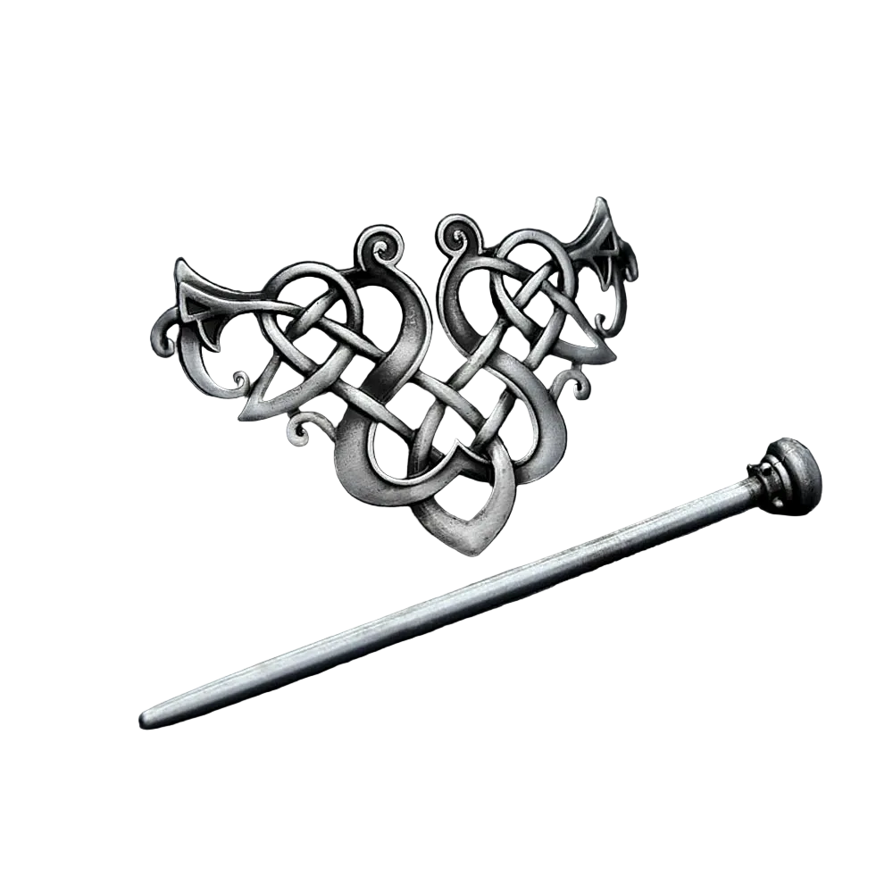 Silver hairpin with intricate design on a dark textured surface